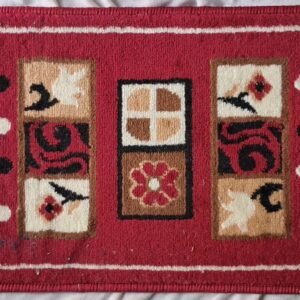 Red rug with floral and geometric pattern featuring beige, black, and white accents.